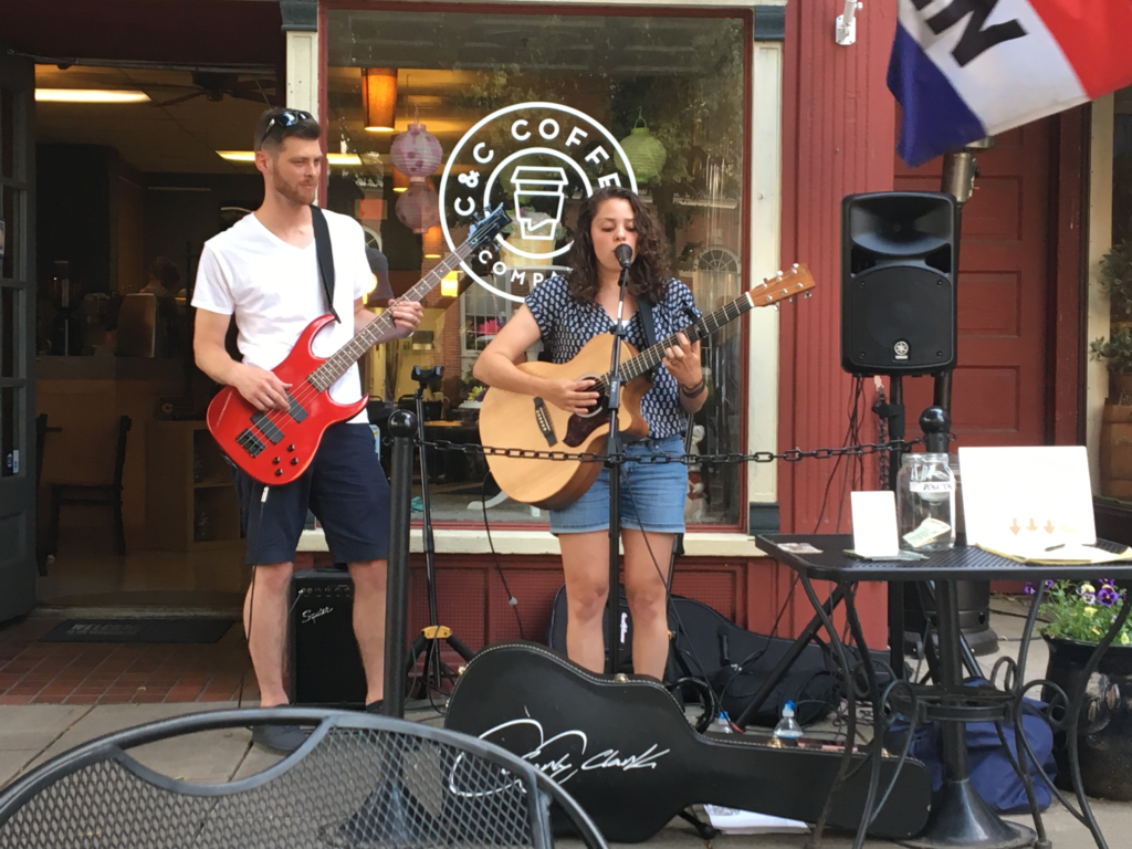 Carly Clark and her back-up guitarist/husband, Todd, performing in front of C & C Coffee Company. Photo by Jenna Kauffman
